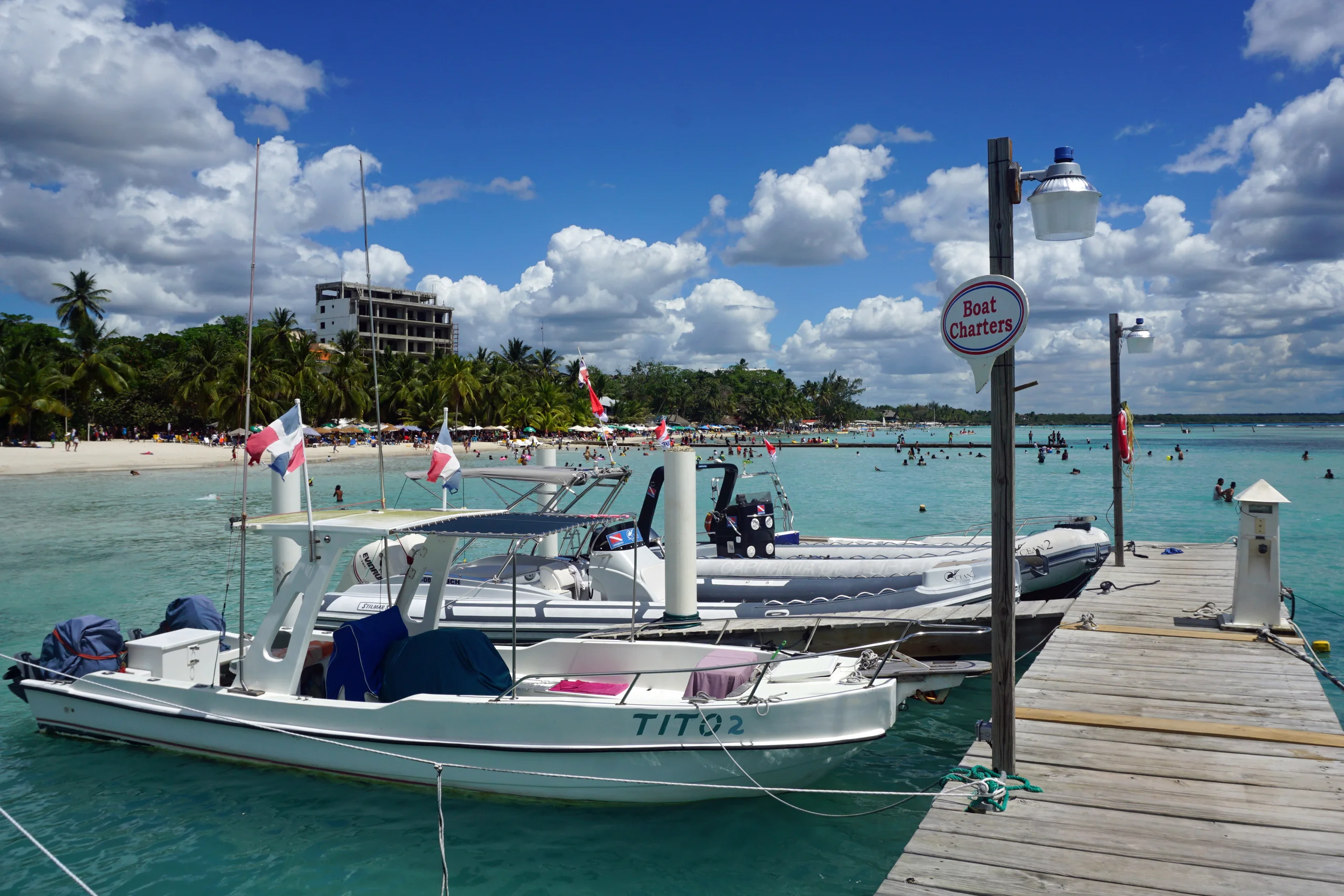 Bote de madera en la orilla de Boca Chica con vegetación tropical y aguas cristalinas